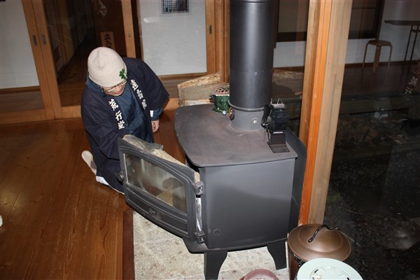 暖炉に薪をくべる